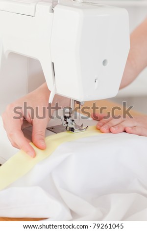 Caucasian hands using a sewing machine in the living room