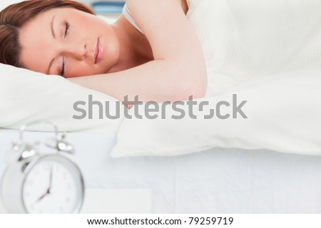 Charming red-haired woman sleeping in her bed