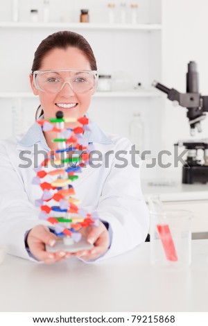 Portrait of a beautiful scientist showing the dna double helix model