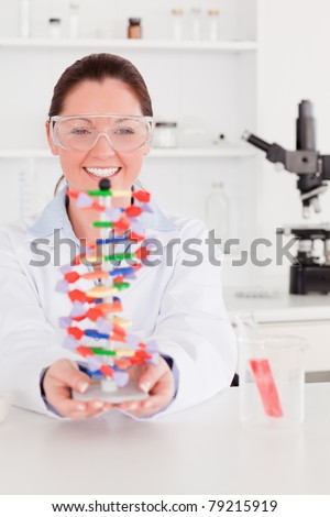 Portrait of a smiling scientist showing the dna double helix model