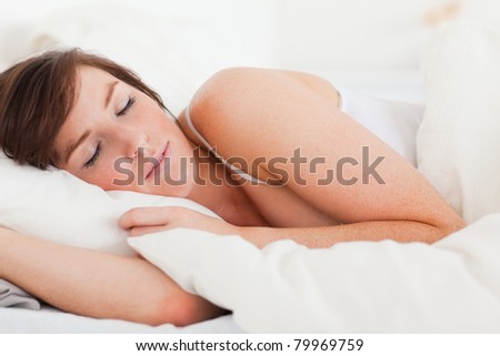 Beautiful brunette female having a rest while lying on a bed