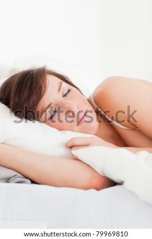 Good looking brunette female having a rest while lying on a bed