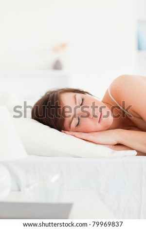 Lovely brunette female having a rest while lying on a bed