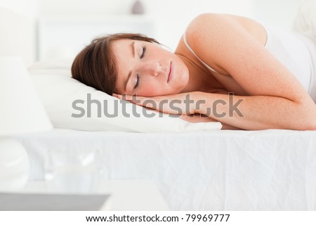 Cute brunette female having a rest while lying on a bed