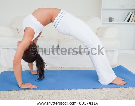Athletic young woman practicing yoga in her living room