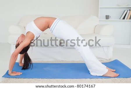 Cute young woman practicing yoga in her living room
