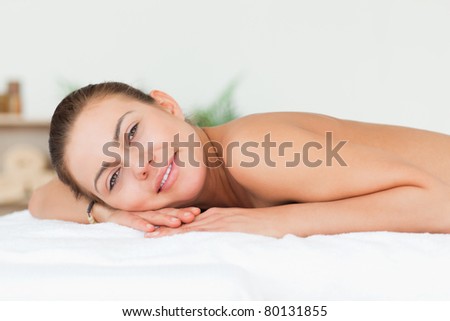 Woman lying on her belly looking at the camera in a spa