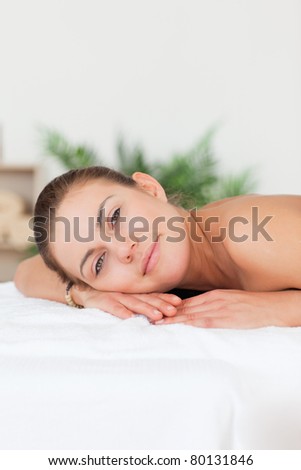 Portrait of a woman lying on her belly looking at the camera in a spa