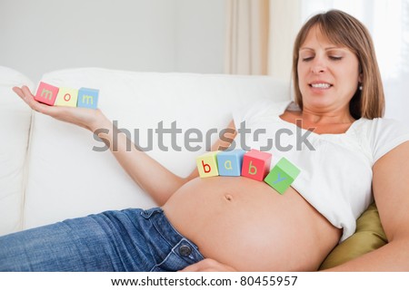 Mother to be chilling out with toys in her living room