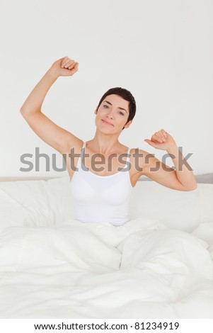 Portrait of a cute woman stretching her arms to wake up