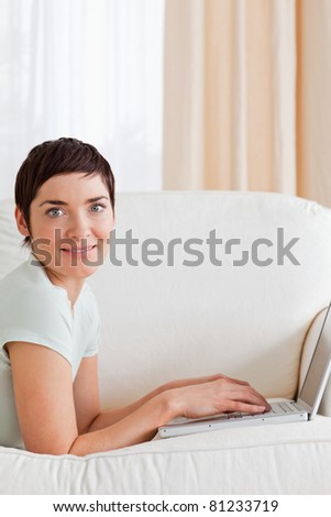 Portrait of a  cute short-haired woman with a laptop in her living room