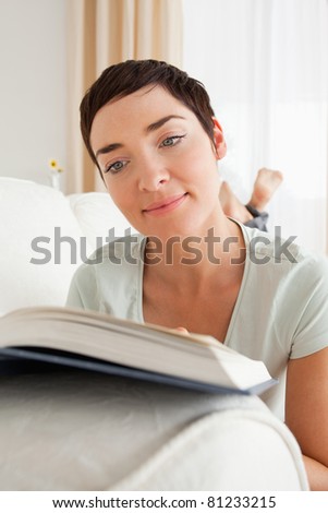 Portrait of a short-haired woman reading a book in her living room