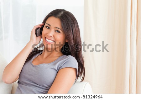 lady on sofa with mobile in hand looking into camera in living room
