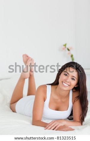charming woman lying on bed in bedroom with crossed legs