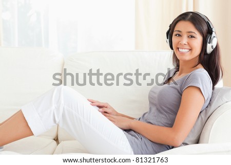 woman with earphones sitting on sofa in living room