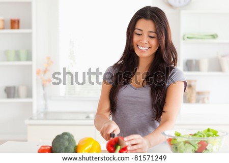 Beautiful woman cooking vegetables while standing in the kitchen