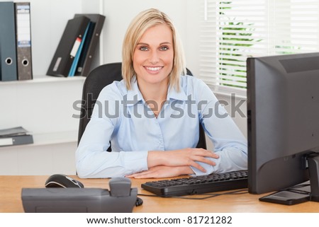 Smiling woman sitting behind a desk in an office