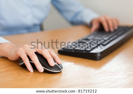 woman with hands on mouse and keyboard in her office