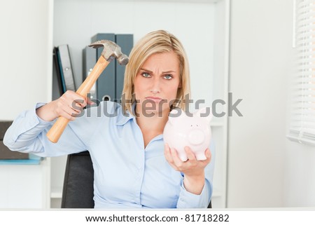 sulking woman wanting to destroy her piggy bank in her office