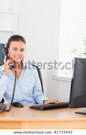 Office worker making a phone call looking at the camera