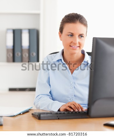 Close up of an office worker typing on a keyboard in her office