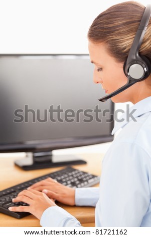 Secretary with a headset working on her computer in her office