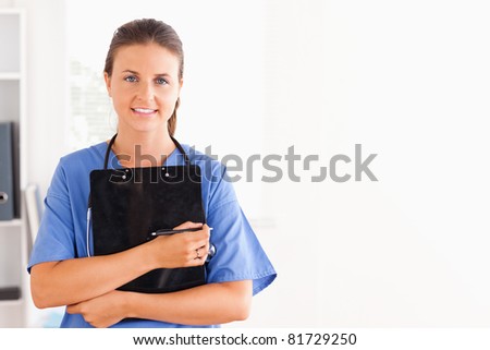 Smiling nurse holding a folder while looking at the camera