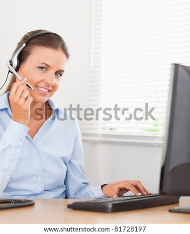 An operator with a headset sits in an office and helps someone