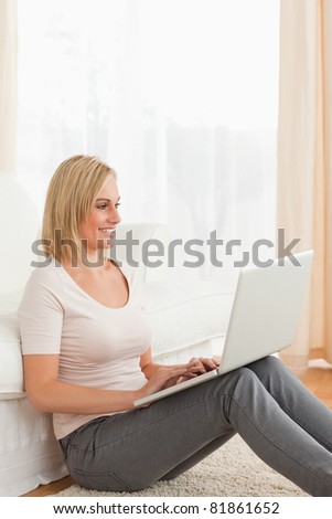 Portrait of a fair-haired woman using a laptop in her living room