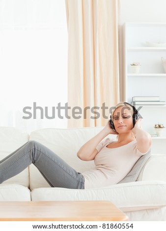 Delighted woman listening to music in her living room