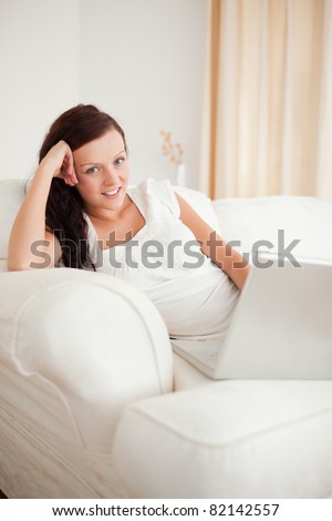 Relaxed red-haired woman with headphones looking into the camera in the living room