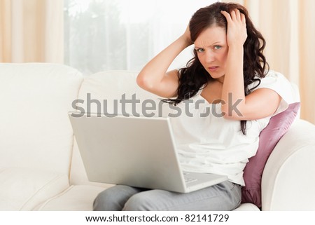 Close up of a frustrated woman with a laptop in the living room