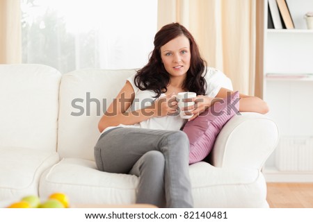 Woman drinking coffee in her living room