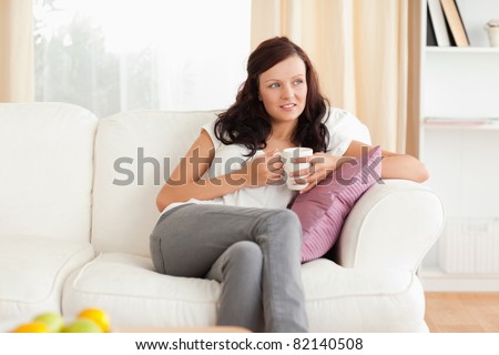Portrait of a cute posing woman on a sofa in her living room