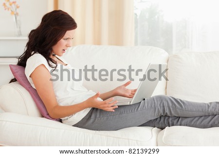 Annoyed woman with a laptop in her living room