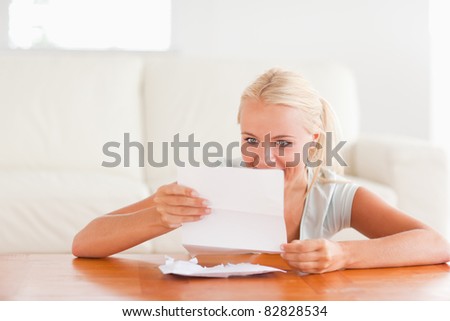 Happy woman reading a letter in her living room