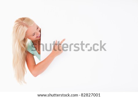 Joyful cute woman pointing at a whiteboard in a studio
