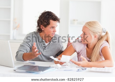 Couple arguing on expenses in their living room