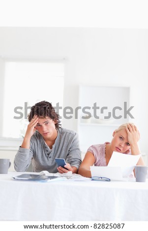 Worn out couple calculating their expenses in the living room