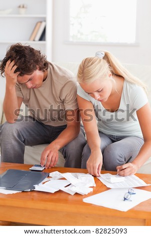 Despaired couple calculating their expenses in the living room