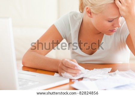 Sad blond woman accounting in the living room