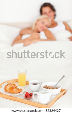 Couple with the breakfast put on a tray with the camera focus on the object