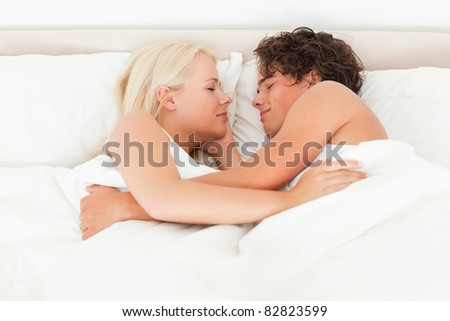 Couple sleeping facing each other in their bedroom
