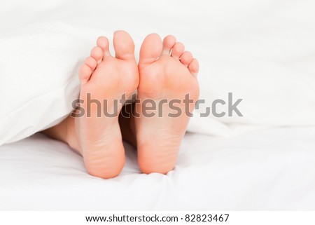 Close up of feminine feet in a bed