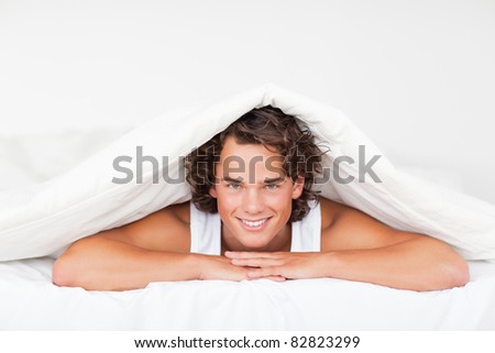 Man under a duvet in a bed