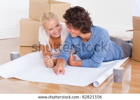 Happy couple getting ready to move in a new house while lying on the floor