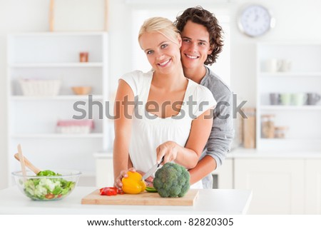 Lovely couple slicing pepper in their kitchen