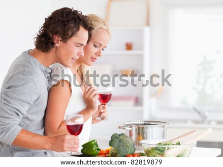 Couple cooking while having a glass of wine in their kitchen