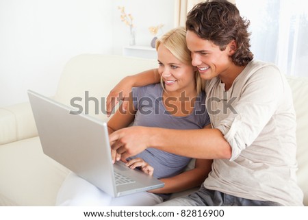 Man showing something to his wife on a notebook in their living room