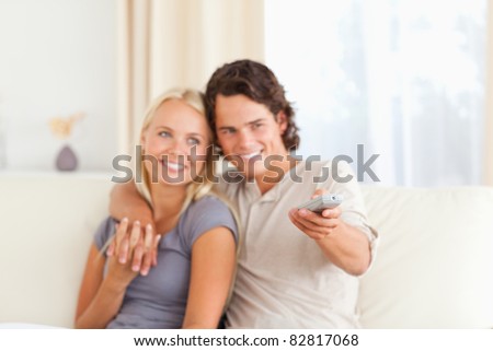 Young couple watching TV in their living room